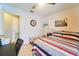 Cozy bedroom featuring tile floors, ceiling fan, and a comfortable bed with striped bedding at 7205 San Luis Ct, Tampa, FL 33634
