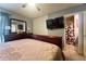 This bedroom features tile floors, a ceiling fan, a tv and ensuite bathroom at 7205 San Luis Ct, Tampa, FL 33634