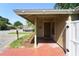 Home featuring a quaint, covered front porch with red tile and garden landscaping at 7205 San Luis Ct, Tampa, FL 33634
