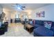 Inviting living room featuring a blue sectional sofa and neutral tile flooring at 7205 San Luis Ct, Tampa, FL 33634