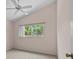 Bedroom with carpeting, ceiling fan, and a window overlooking trees at 731 Waterside Ct, Tarpon Springs, FL 34689