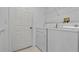 This laundry room features a washer, dryer, a door and shelving at 731 Waterside Ct, Tarpon Springs, FL 34689