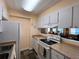 Functional kitchen with white cabinetry and countertops, with a view of the adjacent living area at 7910 Sun Island S Dr # 203, South Pasadena, FL 33707