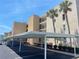 View of assigned covered parking and manicured landscaping surrounding the building at 7910 Sun Island S Dr # 203, South Pasadena, FL 33707