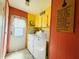 Bright laundry room featuring side-by-side washer and dryer, storage and exterior door at 808 53Rd E Ave # 142K, Bradenton, FL 34203