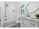 Well-lit bathroom features a shower over the tub, stylish vanity, and round mirror at 8727 Bay Crest Ln, Tampa, FL 33615