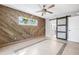 Spacious bedroom featuring stylish wood wall, tile floors, and a modern ceiling fan at 8727 Bay Crest Ln, Tampa, FL 33615