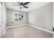 This bedroom has light grey walls, a ceiling fan, tile floor and view to the outside at 8727 Bay Crest Ln, Tampa, FL 33615