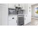 Kitchen counter with white cabinets, beverage cooler, and gray subway tile backsplash at 8727 Bay Crest Ln, Tampa, FL 33615