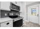 Close-up of the kitchen range with stainless steel microwave and stove with white cabinetry at 8727 Bay Crest Ln, Tampa, FL 33615