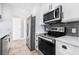 Modern kitchen with stainless steel appliances, white cabinets, and tile backsplash at 8727 Bay Crest Ln, Tampa, FL 33615