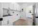 Laundry room with a stainless sink, white cabinets and access to the outside at 8727 Bay Crest Ln, Tampa, FL 33615