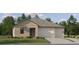 Charming single-story home with a two-car garage, stone facade, and well-manicured lawn, inviting and full of curb appeal at 9590 Runaway Breeze Dr, Land O Lakes, FL 34637