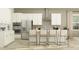 Modern kitchen with white cabinets, stainless steel appliances, and bar stool seating at the island at 9590 Runaway Breeze Dr, Land O Lakes, FL 34637