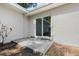 Back patio features a sliding door, neutral paint, and a small garden at 1105 Oakview Ave, Clearwater, FL 33756