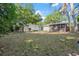 Expansive backyard shows the white house, back patio and screened in porch at 1105 Oakview Ave, Clearwater, FL 33756