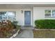 Charming entryway with a blue front door, stylish exterior lighting, and beautifully landscaped garden beds at 1105 Oakview Ave, Clearwater, FL 33756
