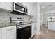 Modern kitchen features stainless steel appliances, white cabinets, granite countertops and backsplash at 1105 Oakview Ave, Clearwater, FL 33756