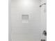 Bathroom shower featuring modern white textured tile, a built-in niche, and contemporary shower fixtures at 1105 Oakview Ave, Clearwater, FL 33756
