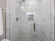 Modern shower featuring white textured tile, a glass door, and a shower head with sleek, contemporary fixtures at 1105 Oakview Ave, Clearwater, FL 33756