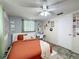A cozy bedroom with an orange bedspread, tapestry wall hanging and desk at 11634 Meadow Dr, Port Richey, FL 34668