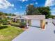 Charming home featuring a manicured front yard with lush landscaping and a driveway at 11634 Meadow Dr, Port Richey, FL 34668