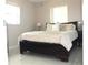 Bedroom with a large bed, side table, and windows with blinds at 12400 Park Blvd # 111, Seminole, FL 33772