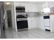 Well-lit kitchen featuring white cabinets, stainless steel appliances, and tiled backsplash at 12400 Park Blvd # 111, Seminole, FL 33772