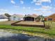 A view of the yard showing fencing and a screened in porch, with view of the pond at 12531 Midpointe Dr, Riverview, FL 33578