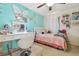 Stylish bedroom featuring a turquoise accent wall with butterfly decor and vanity space with lighted mirror at 12531 Midpointe Dr, Riverview, FL 33578