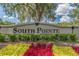 South Pointe community sign with colorful flower beds and a large, mossy tree overhead at 12531 Midpointe Dr, Riverview, FL 33578