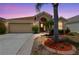 Charming single-story home with landscaped front yard and attached two-car garage at dusk at 12531 Midpointe Dr, Riverview, FL 33578