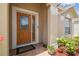 Inviting front door with decorative glass, sidelight and manicured landscaping at 12531 Midpointe Dr, Riverview, FL 33578