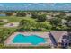 Aerial view of a community pool, sun deck, clubhouse, playground, and open green space at 12531 Midpointe Dr, Riverview, FL 33578