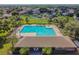 Aerial view of a community pool, sundeck, palm trees, clubhouse, and surrounding neighborhood at 12531 Midpointe Dr, Riverview, FL 33578