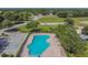 Aerial view of a community pool, sun deck, parking area, playground, and open green space at 12531 Midpointe Dr, Riverview, FL 33578