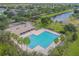 Community pool with palm trees, parking and covered seating adjacent to a beautiful pond at 12531 Midpointe Dr, Riverview, FL 33578