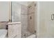 Modern shower with clear glass door, neutral tile, and pebble stone flooring for a spa-like retreat at 12531 Midpointe Dr, Riverview, FL 33578