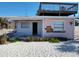 Damaged pink bungalow with sand yard and stairway to upper deck at 12609 Sunshine Ln, Treasure Island, FL 33706
