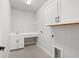 Bright laundry room features a sink, white cabinets, gray tile floors, and connections for a washer and dryer at 1311 S Moody Ave # 1, Tampa, FL 33629