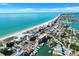 Aerial view showcases beach and ocean and nearby buildings and marina at 13235 Gulf Blvd # 502, Madeira Beach, FL 33708