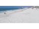Expansive sandy beach with blue ocean waves and people enjoying the sun at 13235 Gulf Blvd # 502, Madeira Beach, FL 33708