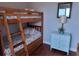 Nautical themed bedroom with wooden bunk beds and adjacent dresser with decorative lamp at 13235 Gulf Blvd # 502, Madeira Beach, FL 33708