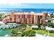 Waterfront condominium complex with multiple balconies, and a boat dock on a sunny day at 13235 Gulf Blvd # 502, Madeira Beach, FL 33708