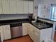 Functional kitchen with stainless steel sink, appliances, and white cabinets at 13235 Gulf Blvd # 502, Madeira Beach, FL 33708