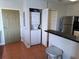 Open kitchen layout with laundry closet and stainless steel refrigerator at 13235 Gulf Blvd # 502, Madeira Beach, FL 33708