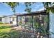 Exterior view of a sunroom or lanai with plants and a well-manicured backyard at 1353 Camelot Ct, Palm Harbor, FL 34684