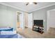 Spacious bedroom with a TV, ceiling fan, and two entrances for convenience at 1353 Camelot Ct, Palm Harbor, FL 34684