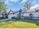 Inviting single-story home boasts a manicured lawn, two-car garage, and classic architectural details at 1353 Camelot Ct, Palm Harbor, FL 34684