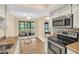 Bright kitchen features stainless steel appliances, tile backsplash, and a cozy breakfast nook with a view at 1353 Camelot Ct, Palm Harbor, FL 34684